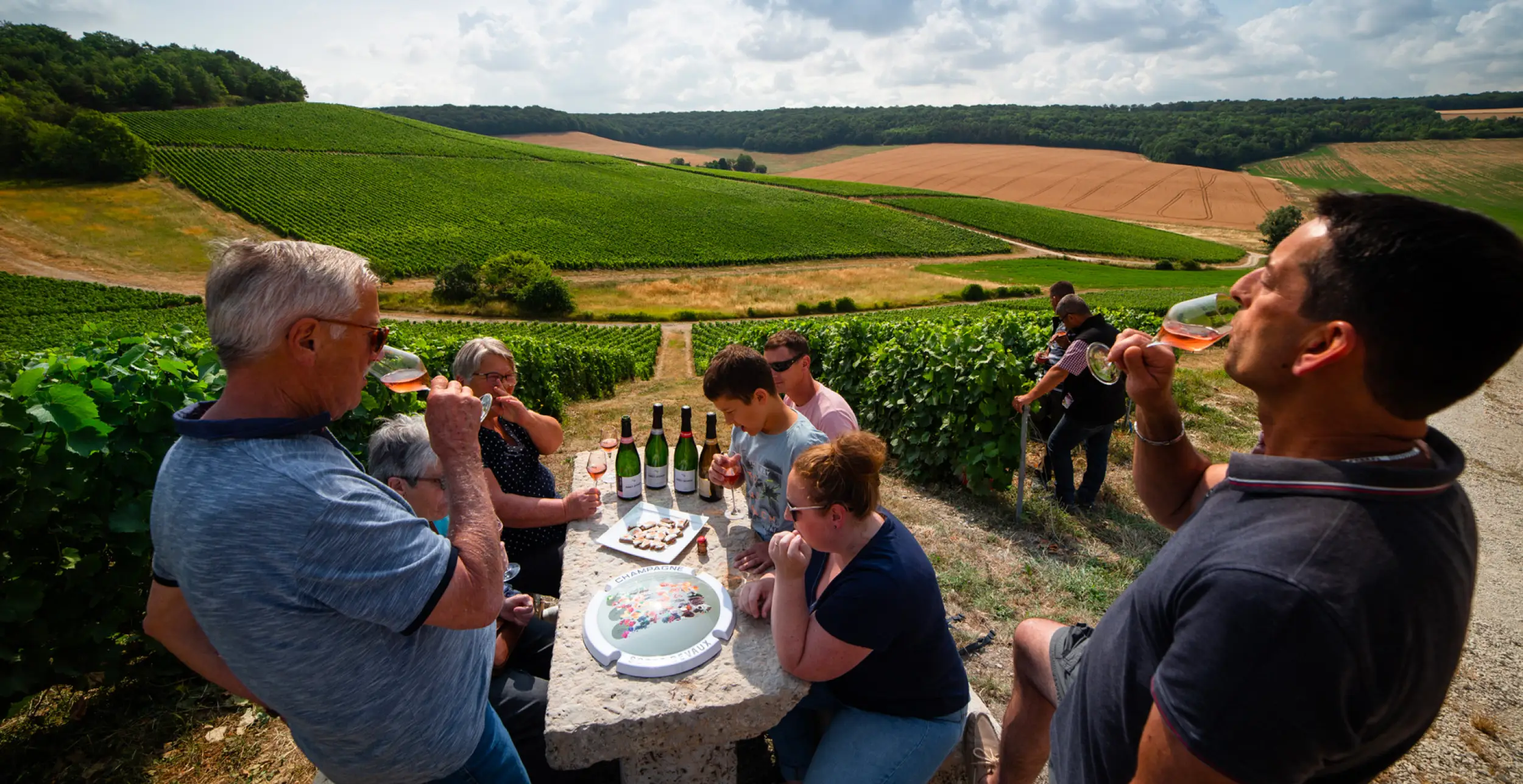 Bouteilles et flutes de champagnes Soret-Devaux sur une table en pierre lors d'une dégustation